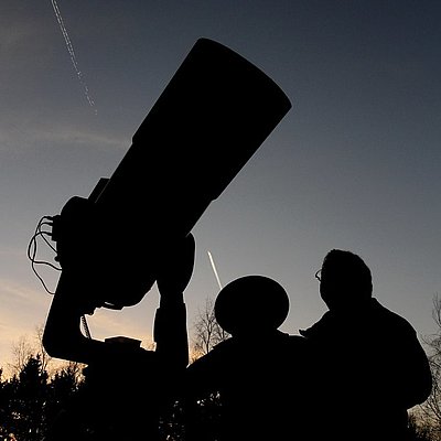 Gäste beobachten den Sternenhimmel durch ein Teleskop
