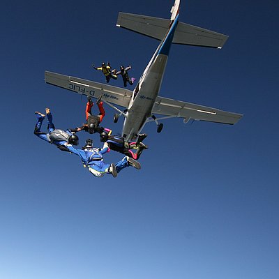Flugzeug mit Fallschirmsprung Formation am blauen Himmel