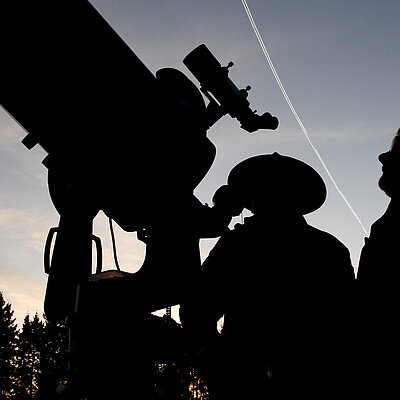 Sternengucker blicken durch ein Teleskop