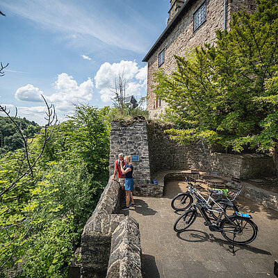 Ein Paar steht mit angelehnten Rädern auf der Burg Blankenheim
