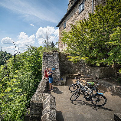 Ein Paar steht mit angelehnten Rädern auf der Burg Blankenheim
