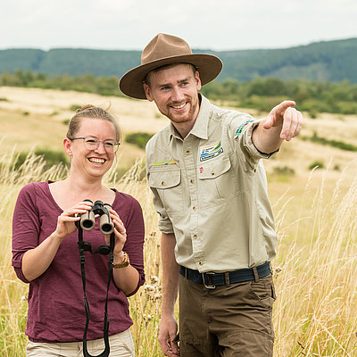 Ranger erklärt einem Gast die Flora und Fauna im Nationalpark Eifel