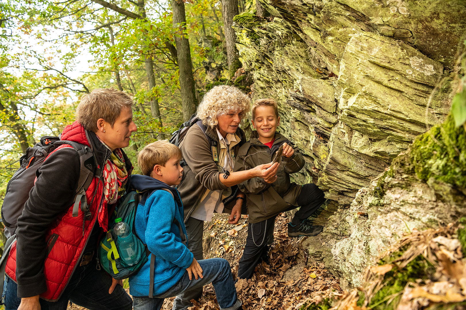 Walsführerin erklärt einer Familie im Nationalpark Eifel eine Gesteinsformation